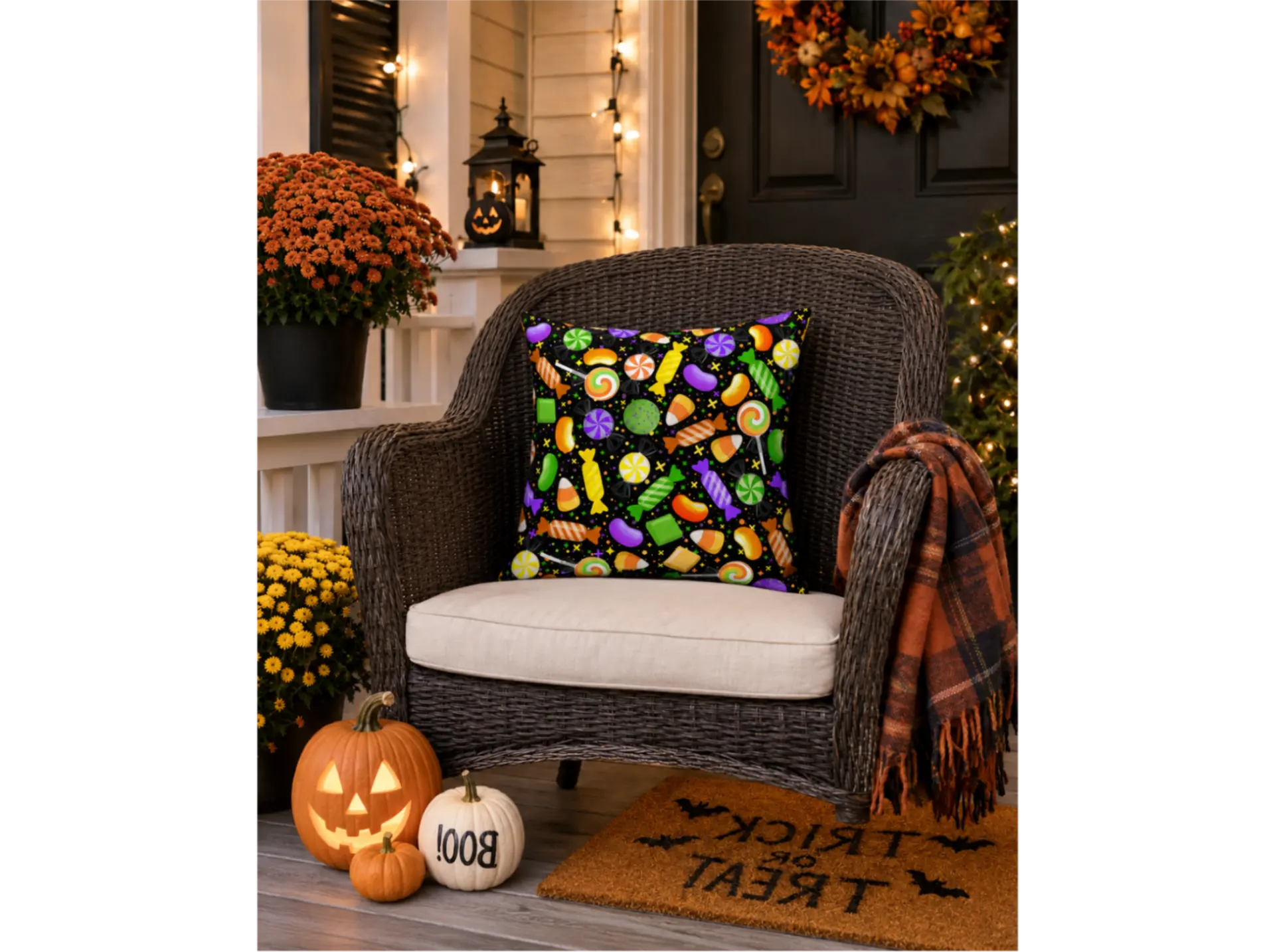 Halloween porch scene with a candy-patterned pillow, pumpkins, and a Trick or Treat mat